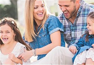 A family of four including a husband, wide, and two young daughters